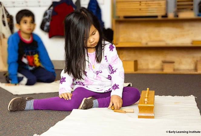 Preschool student using hands-on Montessori math materials during classroom work time