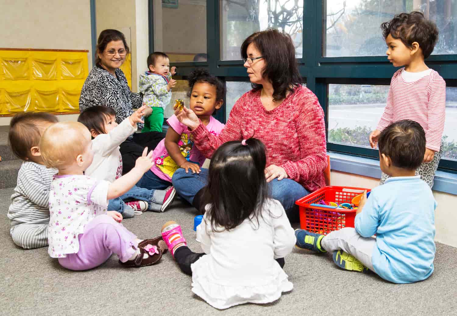 Preschool teacher guiding a small group activity to support social and emotional development