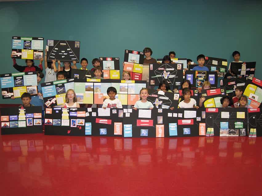 Students displaying completed writing projects created during the WriteNow summer writing camp